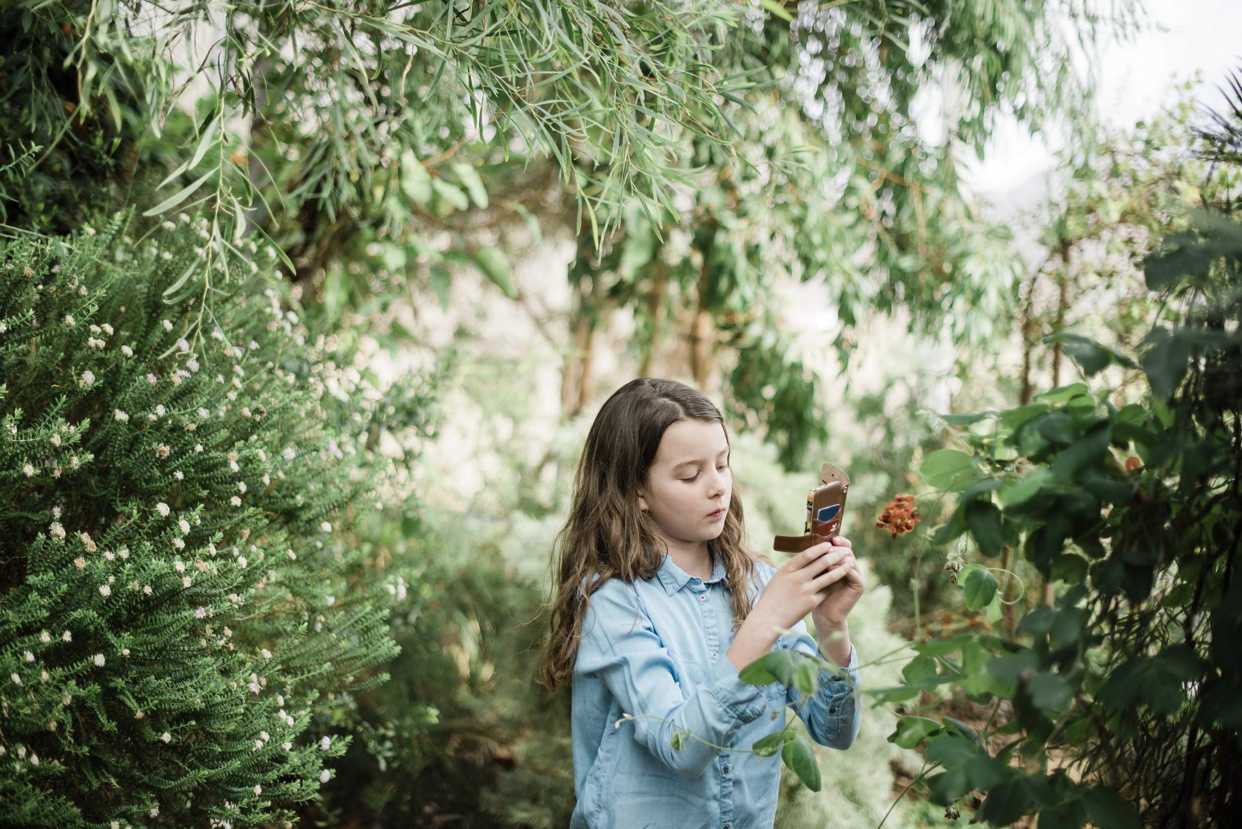 Flicka i naturen som tar bild med mobil