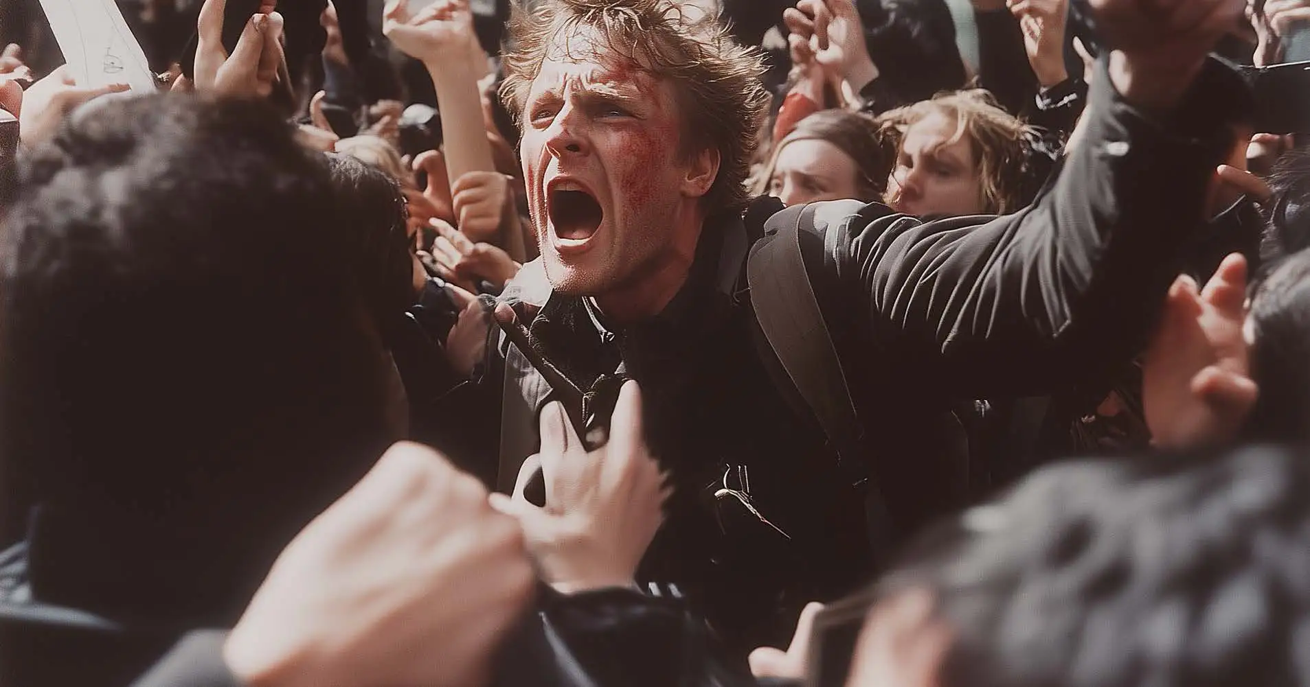 En person omgiven av en trång folkmassa med många uppsträckta armar
