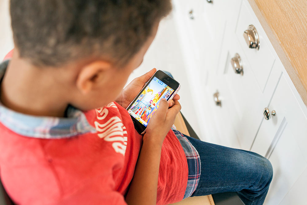 Pojke spelar spel på mobilen