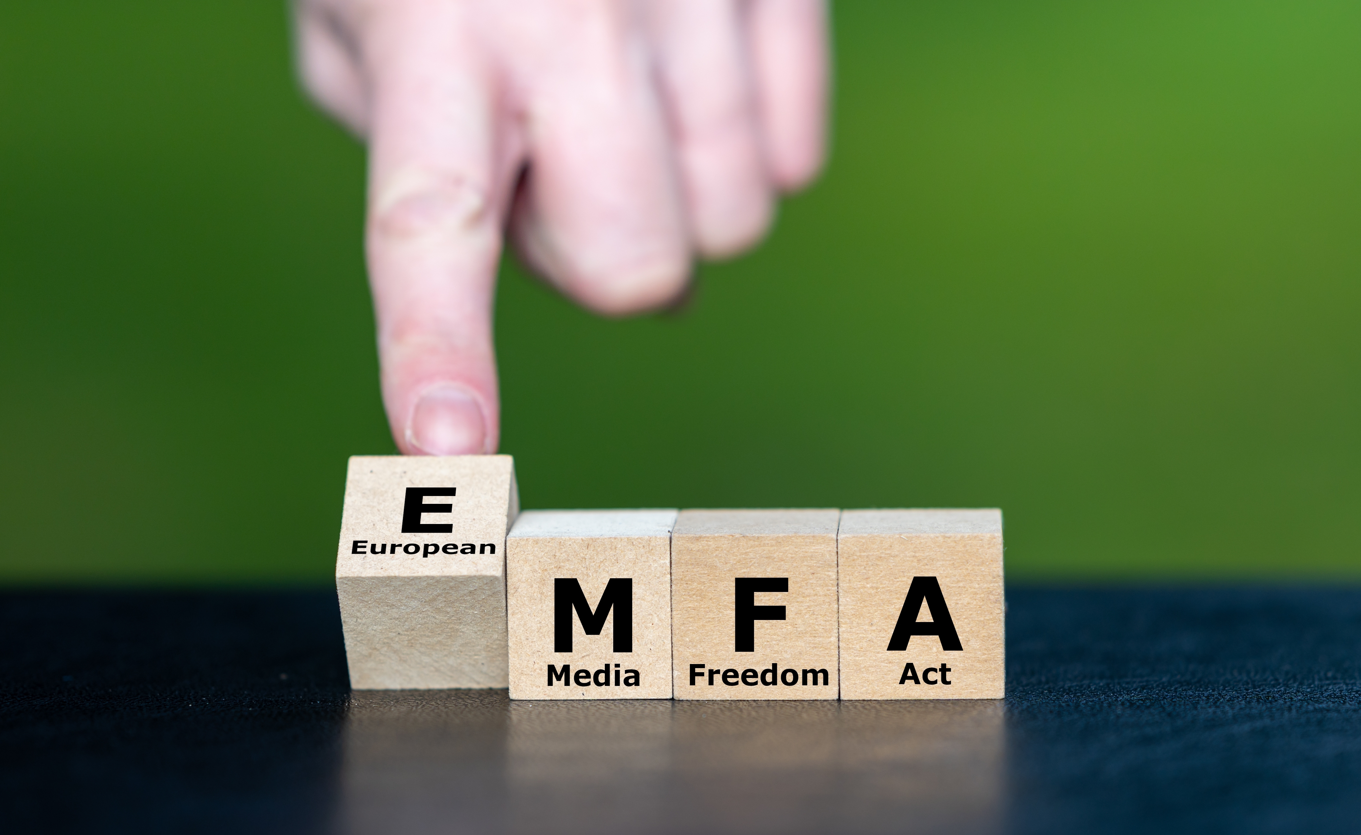 En hand som pekar på träblock med texten EMFA
