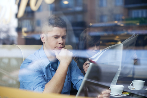Ungdomar på en kajkant tittar i mobiltelefon