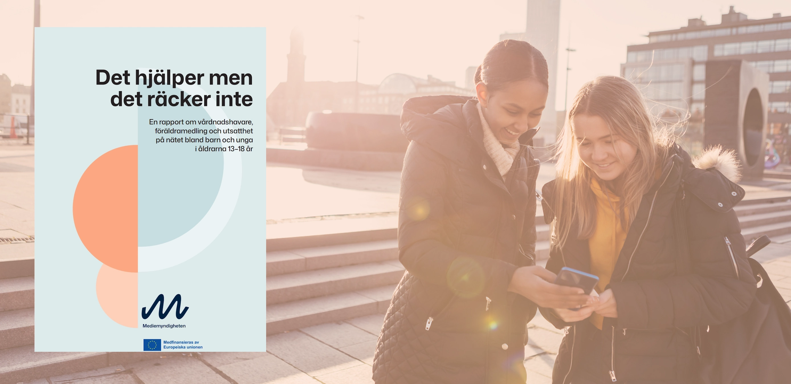 En bild på två unga tjejer som tittar på mobil