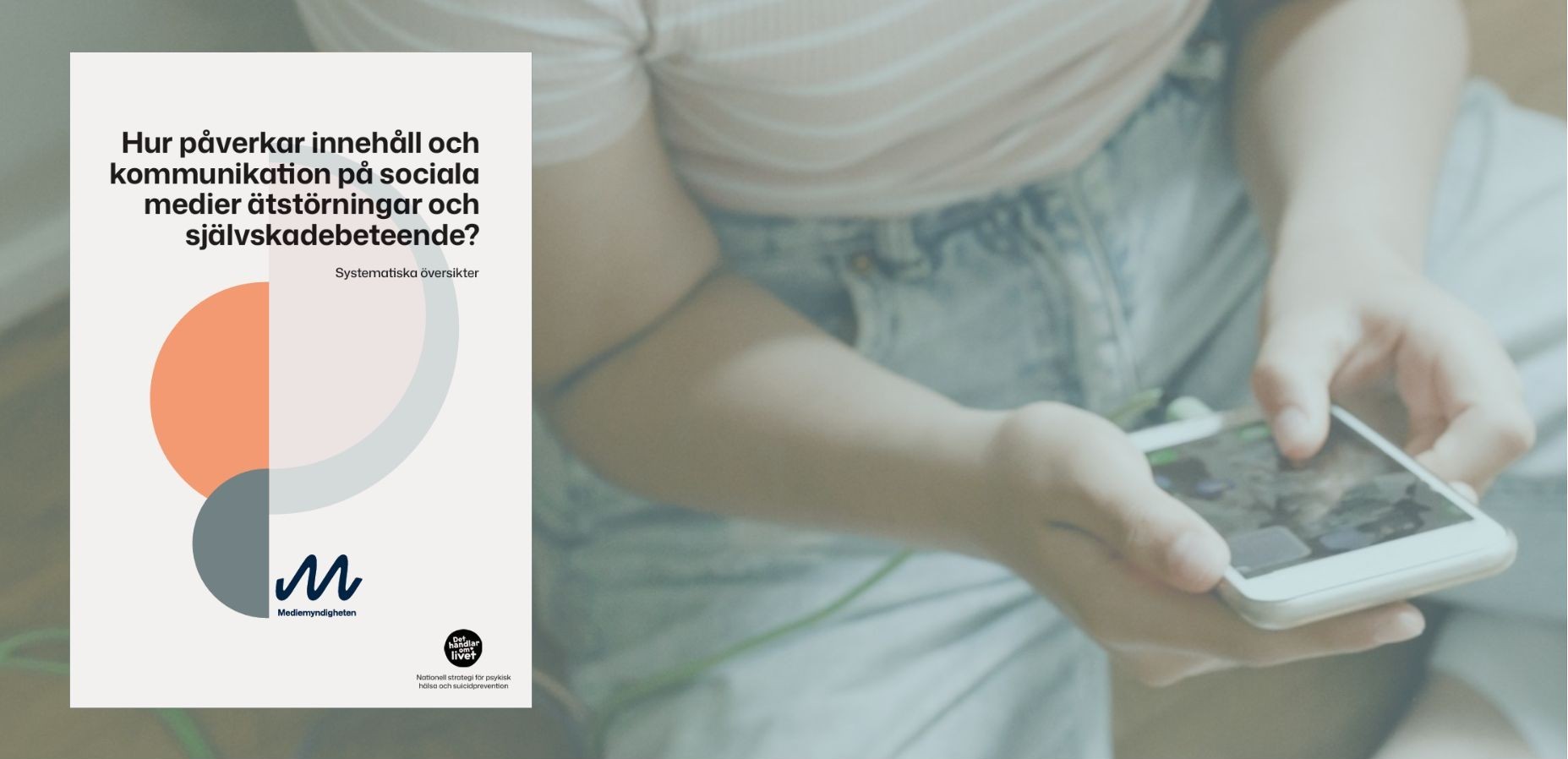 Tjej sitter på golvet och tittar på mobilen
